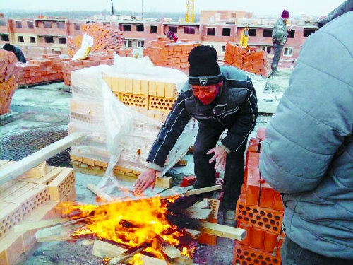 在俄羅斯工地打工時，因?yàn)樘焯?，工人不得不在工地生火取暖。（圖由方先生提供）