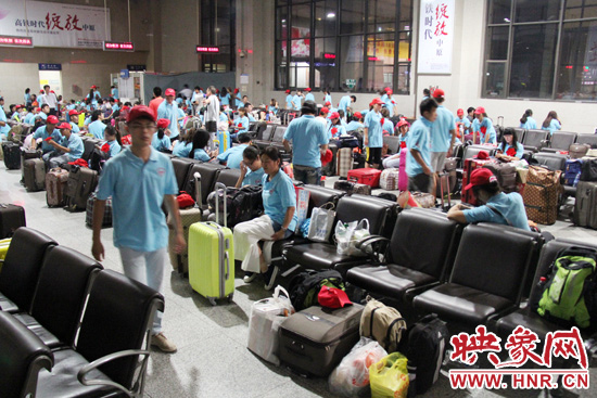 大學生志愿者在火車站候車室內(nèi)整裝待發(fā)。