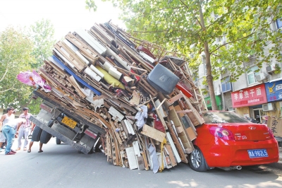 紅色小轎車被砸，卡在路邊動(dòng)彈不得。