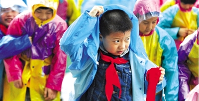昨日下午,農(nóng)科路上一小學放學時,孩子們大部分都穿著雨披。