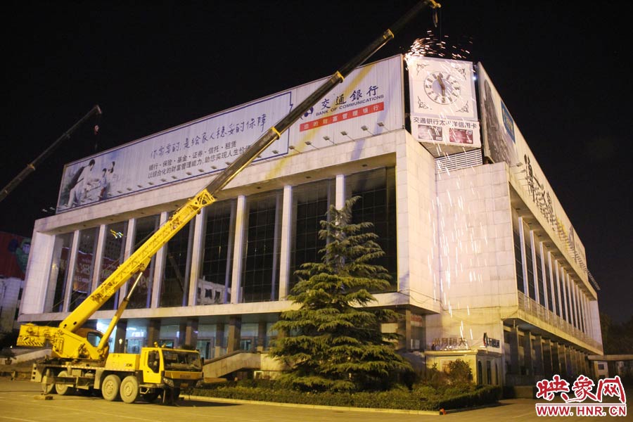 21點(diǎn)50分，切割機(jī)開始對(duì)中間最小的一塊牌進(jìn)行切割。頂著“呼呼”的寒風(fēng)，巨大廣告牌上火花四濺。