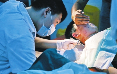 孩子身上有7道傷痕，其中兩道需要縫合，其他的均為擦傷，醫(yī)生正對(duì)他施治。