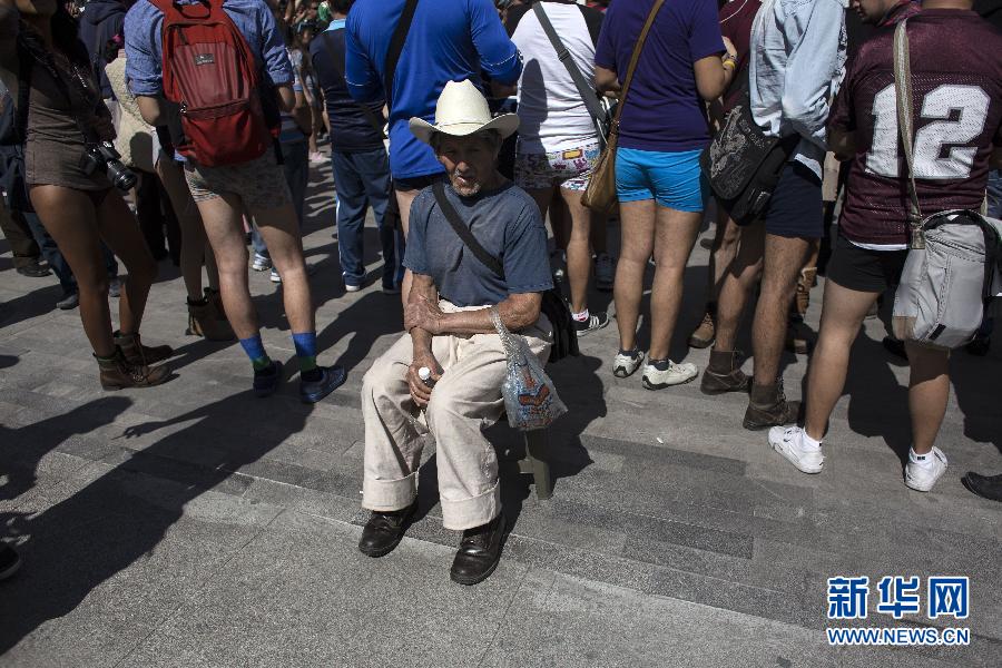 一名男子坐在參加不穿褲子搭地鐵的人群邊小憩。
