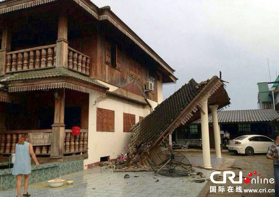 當(dāng)?shù)貢r間2014年5月5日，泰國清萊，一名婦女看著受損的房屋。 圖片來源：東方IC