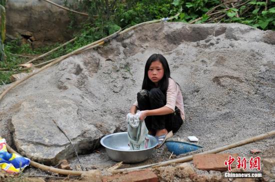 8月9日，云南巧家紅石巖村，10歲的劉鑫蕊在洗自己的衣服