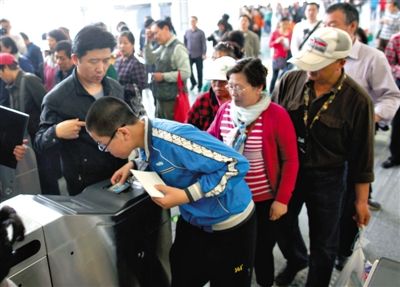 去年5月5日，14號線園博園站，乘客刷卡出地鐵。北京公交地鐵將實行計程票制，多乘坐多付費。