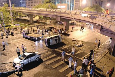路虎沖下國貿(mào)橋砸中一輛起亞轎車，橋上厚達(dá)幾十厘米的水泥護(hù)欄被撞斷，碎石四處散落，數(shù)十群眾在現(xiàn)場圍觀。