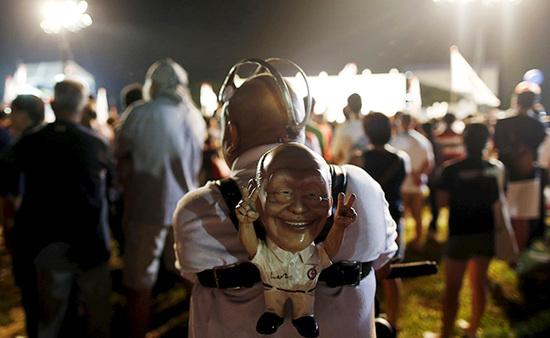 9月4日，新加坡，執(zhí)政黨的一場(chǎng)集會(huì)上，一名支持者背著一個(gè)李光耀的人偶。