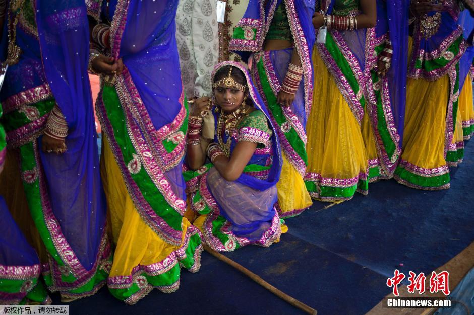 當(dāng)?shù)貢r(shí)間2014年6月15日,印度新德里,印度政府為數(shù)百對貧困新人舉辦集體婚禮。