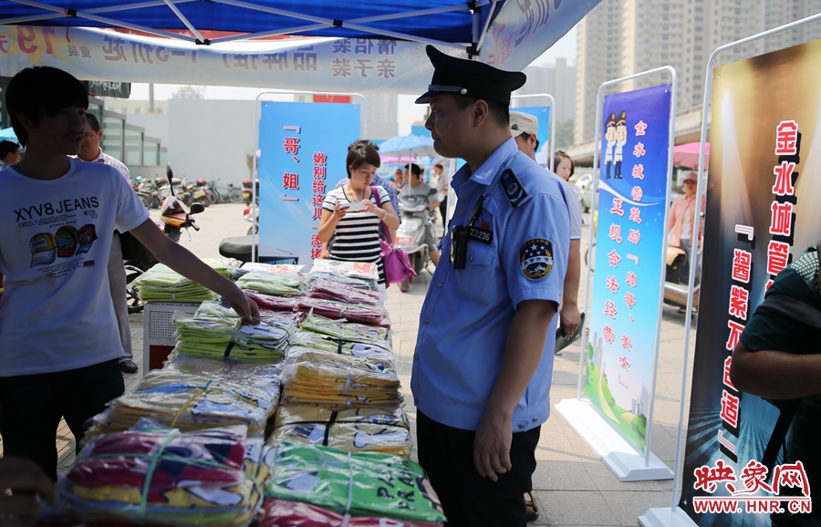 執(zhí)法人員勸導(dǎo)看守?cái)偽坏娜藛T搬離，停止非法占道經(jīng)營(yíng)。