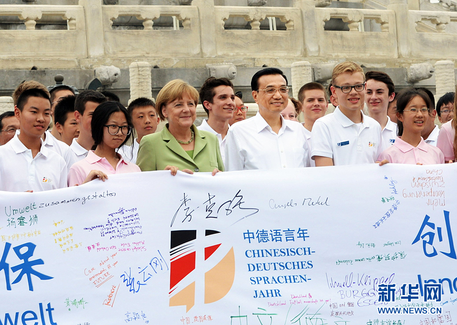 李克強(qiáng)同默克爾與青少年在天壇祈年殿前合影留念。