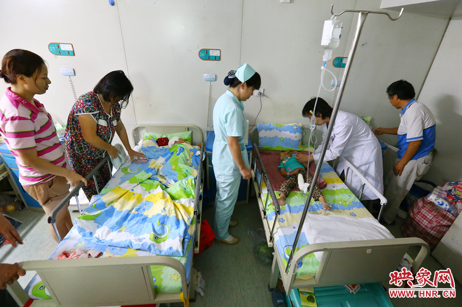 手術(shù)前，畫面右側(cè)的大龍正在接受醫(yī)生的檢查，左側(cè)的小龍還在熟睡。