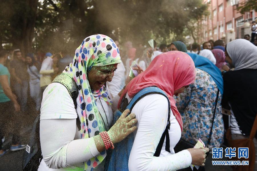 10月16日，在埃及首都開羅，兩名女青年在“彩色跑”活動中躲避人們拋撒的彩色粉末。