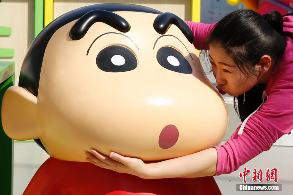 4月22日，游客與蠟筆小新合影?！跋灩P小新25周年紀(jì)念特展”日前在北京開展，吸引了不少市民游客。