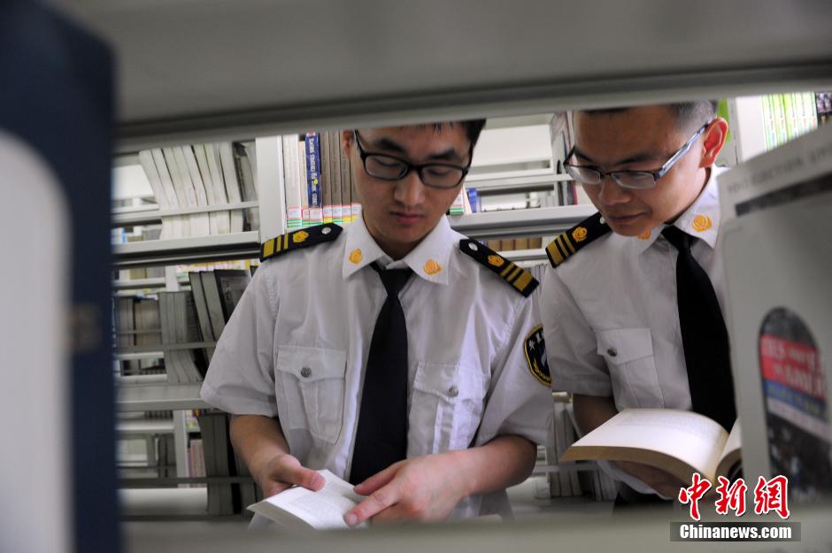 5月8日，武漢輕工大學(xué)圖書館保安吳濤與江力在圖書館交流學(xué)習(xí)。