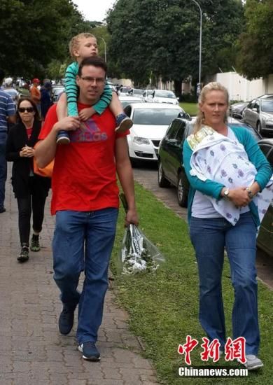 圖為一個白人家庭，由父母帶著孩子到曼德拉家門外悼念。中新社發(fā) 宋方燦 攝