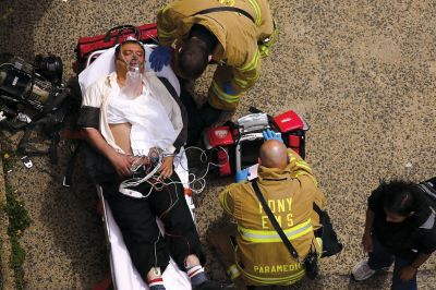 2日，救援人員在美國紐約地鐵事故車輛內(nèi)緊急疏散一名受傷乘客。圖/CFP