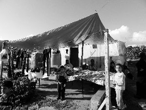 黎巴嫩一敘利亞難民營(yíng)，難民支起攤鋪賣衣服掙錢。