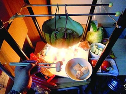 兩張椅子被面對(duì)面疊在一起，穿了兩根線的西瓜皮就懸空在椅腳中間，下面有蠟燭加熱，這就是西瓜火鍋。