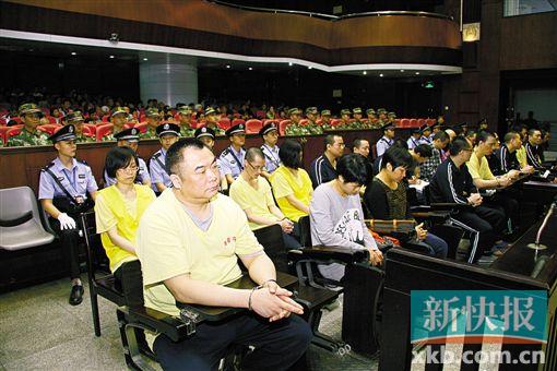 ■蔣洪偉(左一)等二十幾名被告被指控犯集資詐騙罪,昨日集體過(guò)堂?！　?鄭朝暉/攝