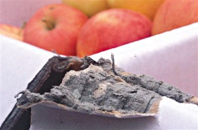 8月29日，新發(fā)地市場，一箱用“加重紙箱”包裝的蘋果正待售，紙箱夾層內(nèi)灰黑色的增重填充物清晰可見