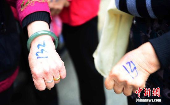 圖為10月28日，在江西九江市一家羊絨皮草服裝服飾博覽會(huì)現(xiàn)場(chǎng)，老人們正在頂著寒風(fēng)排隊(duì)等待領(lǐng)取10元代金劵。