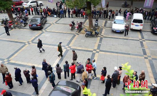 圖為10月28日，在江西九江市一家羊絨皮草服裝服飾博覽會(huì)現(xiàn)場(chǎng)，老人們正在頂著寒風(fēng)排隊(duì)等待領(lǐng)取10元代金劵。