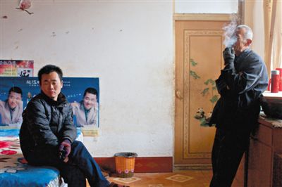 父親抽煙，兒子不語。逃跑的越南新娘，給袁迎賓父子帶來的是失落。新京報記者 周崗峰 攝