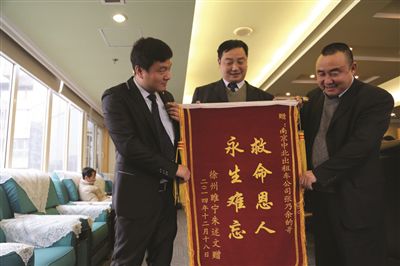 張乃余(中)和兩位救人的同伴一塊領(lǐng)獎。