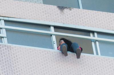 28樓的窗臺上坐著一名女子，其兩條腿耷拉在室外，不停地擺動。