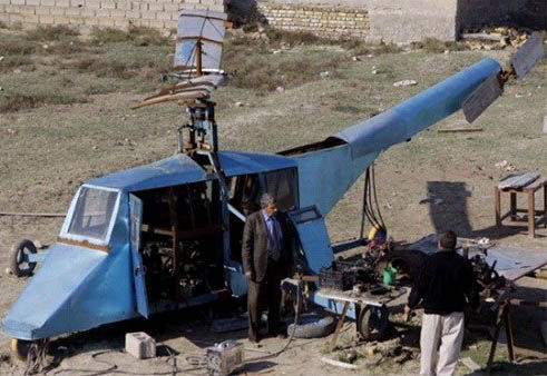 哈蒂姆·卡迪姆·薩爾曼正與工人交談，背后就是他正在制造的直升機(jī)