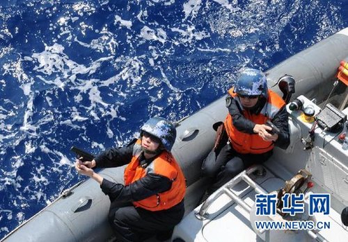 　3月28日，十余名臨檢拿捕隊員乘小艇駛至模擬可疑商船下方水面。