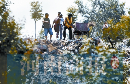 有人正在傾倒建筑垃圾，不遠(yuǎn)處就是村民的水井