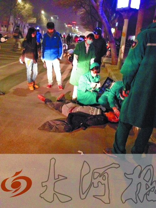 醉漢躺在地上，醫(yī)護人員對其進行檢查。